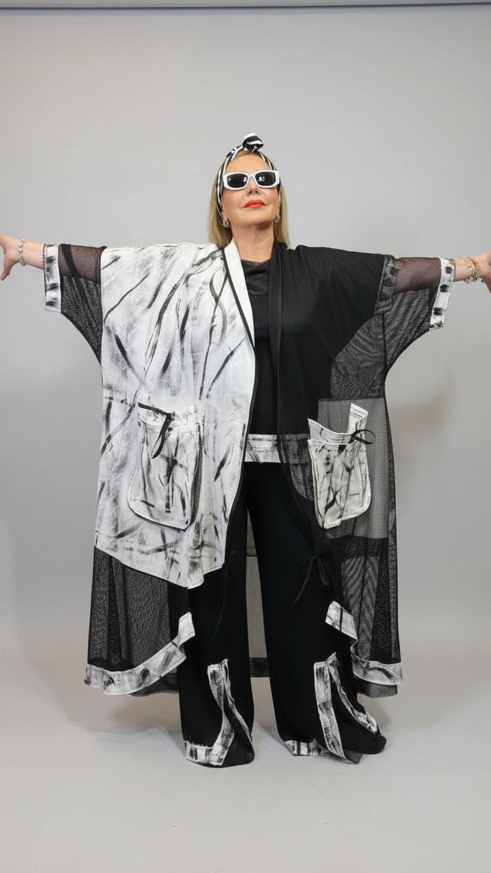 Person wearing a black and white outfit with sunglasses in an indoor setting
