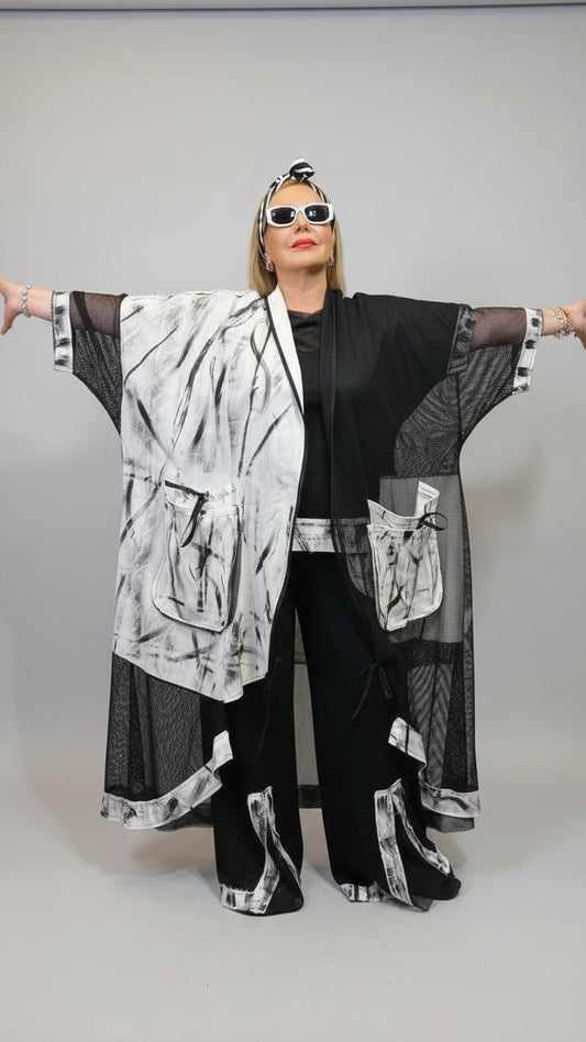 Person wearing a black and white outfit with sunglasses in an indoor setting