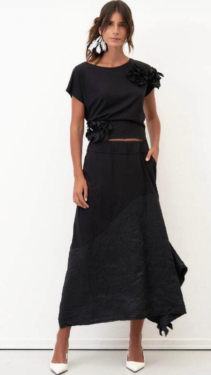 Woman wearing a black outfit with floral details on a white background