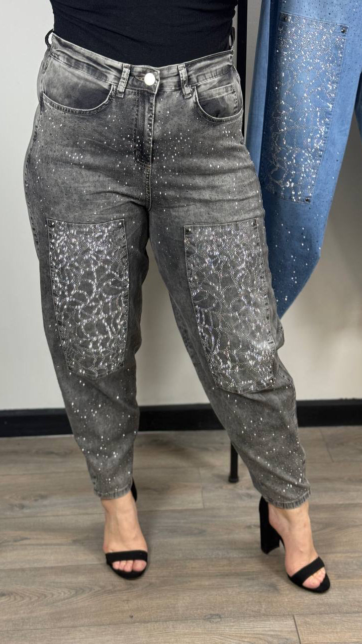 Person wearing gray glittery jeans with a blue sequined jacket in the background.